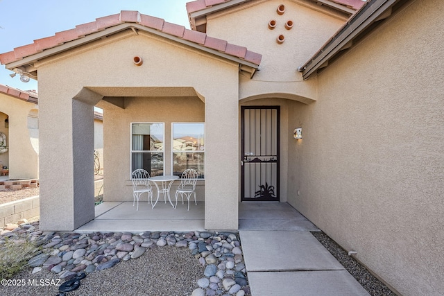 view of exterior entry featuring a patio area