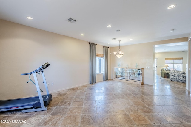 workout area featuring a notable chandelier