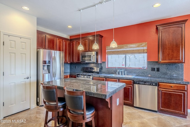 kitchen with sink, a center island, pendant lighting, stainless steel appliances, and decorative backsplash