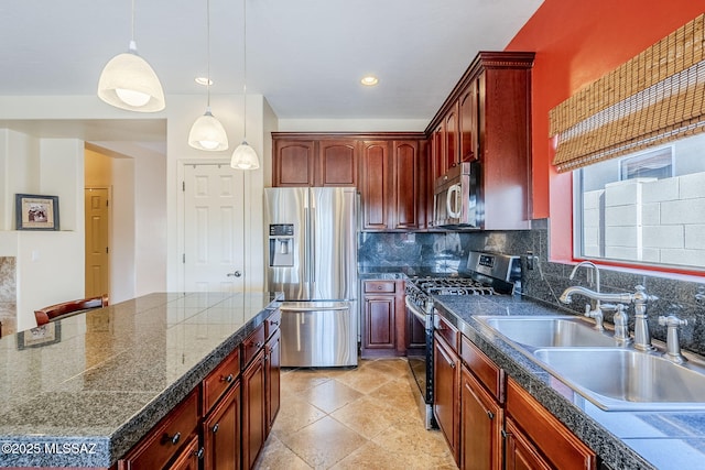 kitchen with sink, stainless steel appliances, tasteful backsplash, a kitchen island, and decorative light fixtures