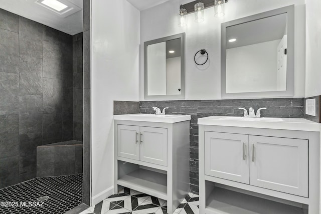 bathroom with vanity, tile patterned flooring, tile walls, and tiled shower