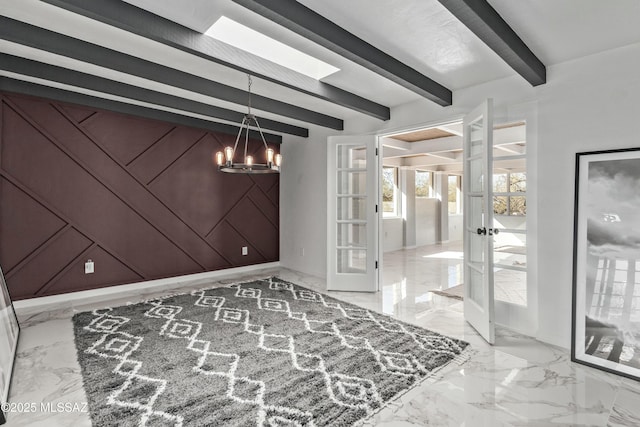 spare room with beam ceiling, wooden walls, an inviting chandelier, and french doors