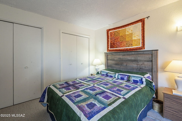 bedroom featuring two closets and a textured ceiling