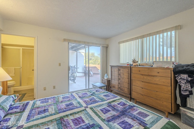 bedroom featuring ensuite bathroom, access to exterior, and a textured ceiling