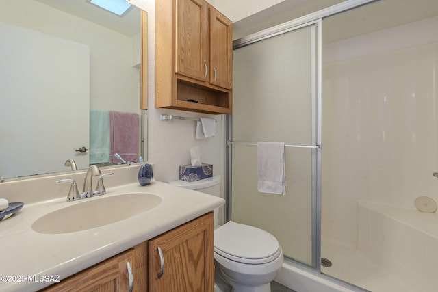 bathroom featuring vanity, toilet, and a shower with shower door