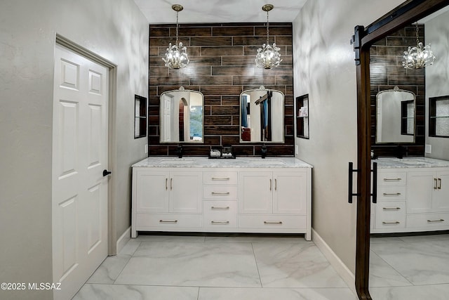 bathroom featuring double vanity, marble finish floor, a sink, and a notable chandelier