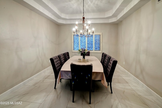 dining room with an inviting chandelier, baseboards, marble finish floor, and a tray ceiling