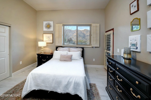 bedroom featuring marble finish floor and baseboards