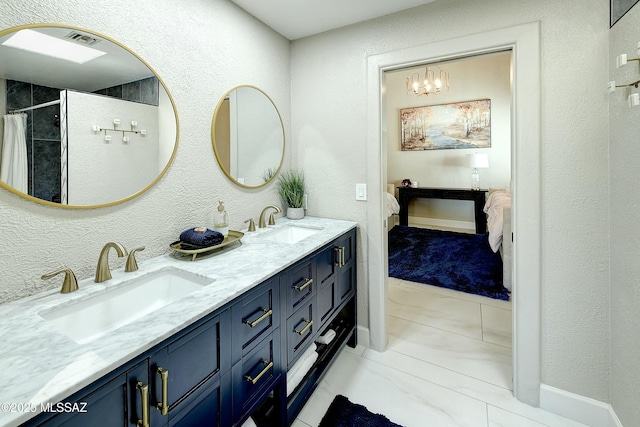 ensuite bathroom with ensuite bathroom, double vanity, a sink, and visible vents