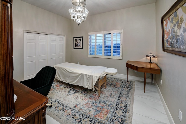 bedroom featuring a chandelier, marble finish floor, a closet, and baseboards