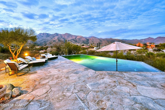 outdoor pool with a patio and a mountain view