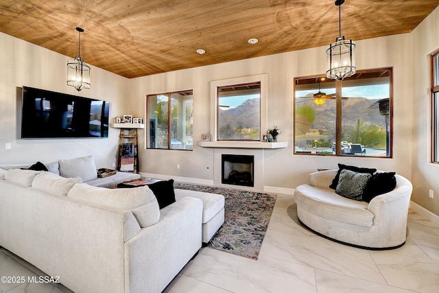 living area with baseboards, wood ceiling, marble finish floor, a fireplace, and a chandelier