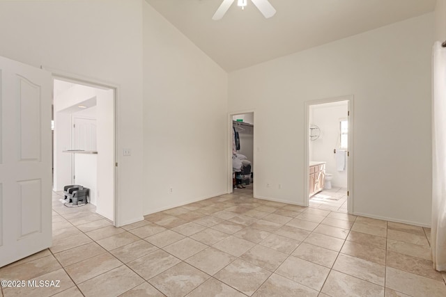 tiled spare room with ceiling fan and high vaulted ceiling