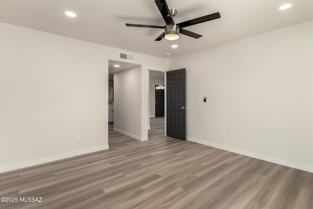 empty room with ceiling fan and light hardwood / wood-style floors