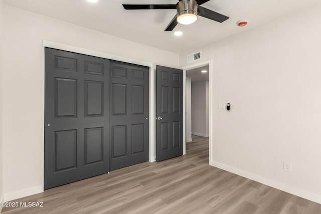 unfurnished bedroom with light hardwood / wood-style flooring, ceiling fan, and a closet