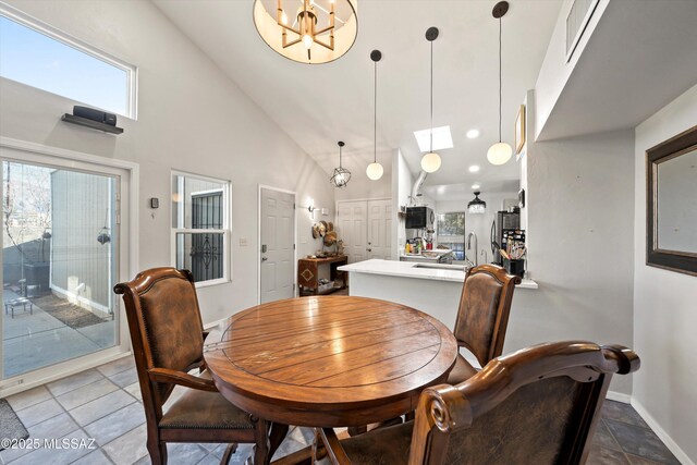 dining area with a tile fireplace and vaulted ceiling