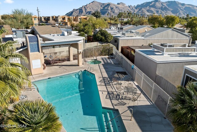 view of pool featuring a community hot tub, a mountain view, and a patio area