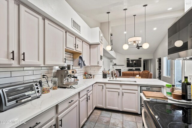 kitchen with gray cabinetry, an inviting chandelier, and appliances with stainless steel finishes