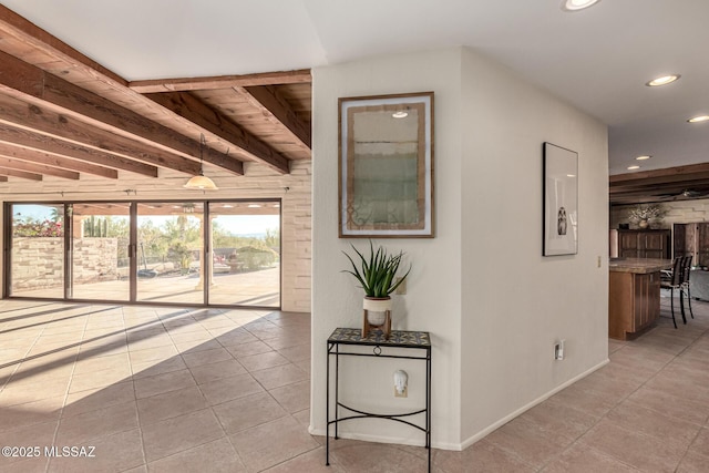 hallway featuring light tile patterned floors and beam ceiling