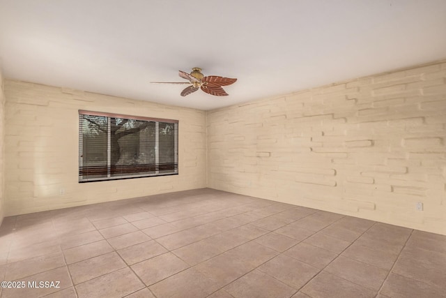 tiled spare room with ceiling fan