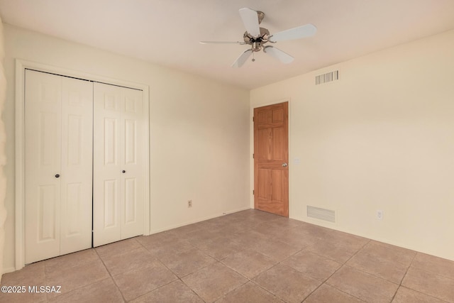 unfurnished bedroom featuring light tile patterned flooring, ceiling fan, and a closet