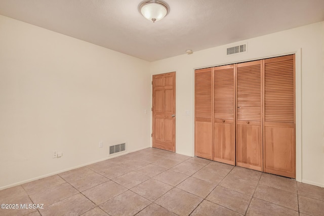 unfurnished bedroom featuring a closet and light tile patterned flooring