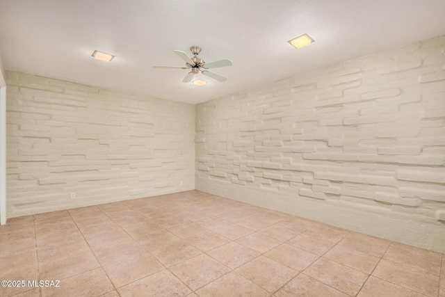 tiled spare room featuring ceiling fan