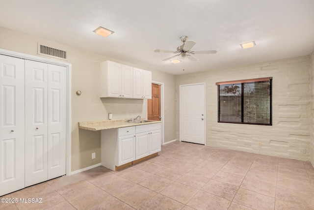 kitchen with ceiling fan, sink, white cabinets, and light tile patterned flooring