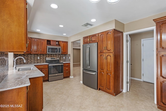 kitchen with stainless steel appliances, sink, and backsplash