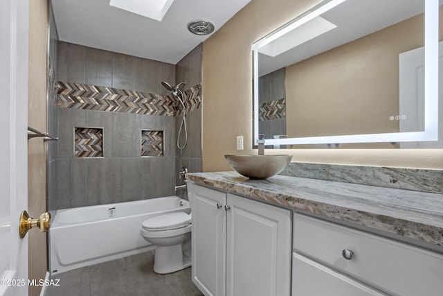 full bathroom with tiled shower / bath, vanity, toilet, and a skylight