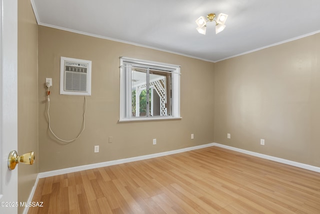 unfurnished room with an AC wall unit, ornamental molding, and light wood-type flooring