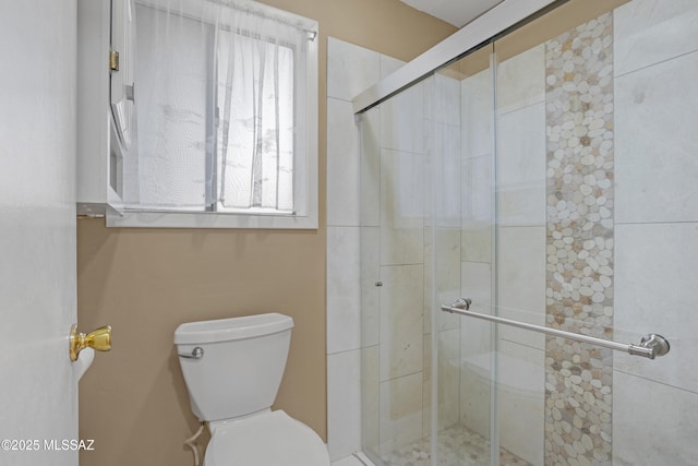 bathroom featuring an enclosed shower and toilet