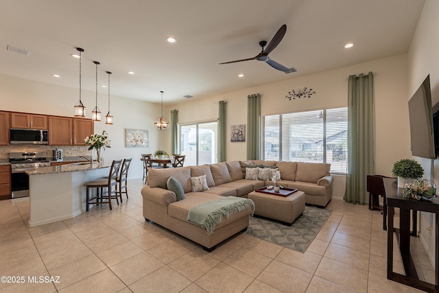 living room with light tile patterned floors, sink, and ceiling fan