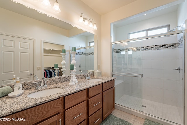 bathroom featuring tile patterned floors, a shower with door, and vanity