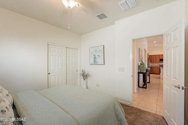 tiled bedroom featuring ceiling fan and a closet