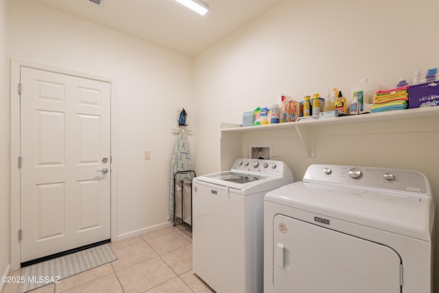 washroom with light tile patterned flooring and washer and clothes dryer