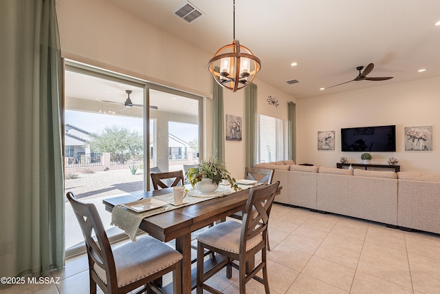 dining area featuring light tile patterned flooring, ceiling fan with notable chandelier, and a wealth of natural light