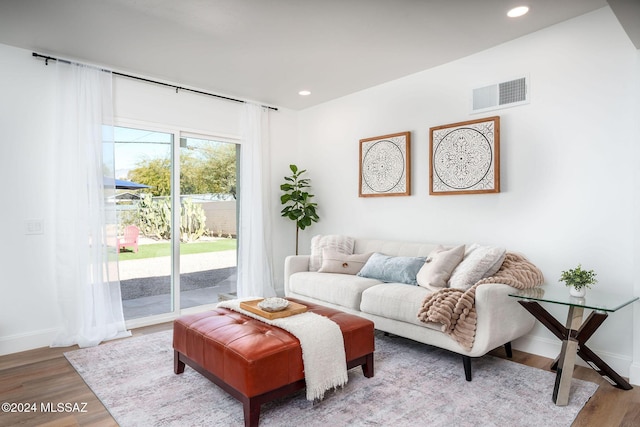 living area with baseboards, wood finished floors, visible vents, and recessed lighting