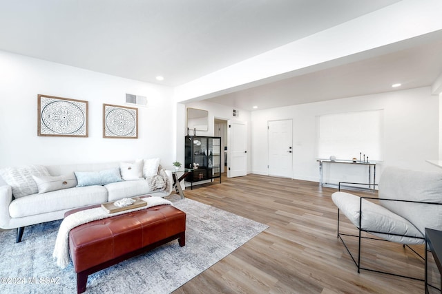 living area featuring light wood-style flooring, visible vents, baseboards, and recessed lighting