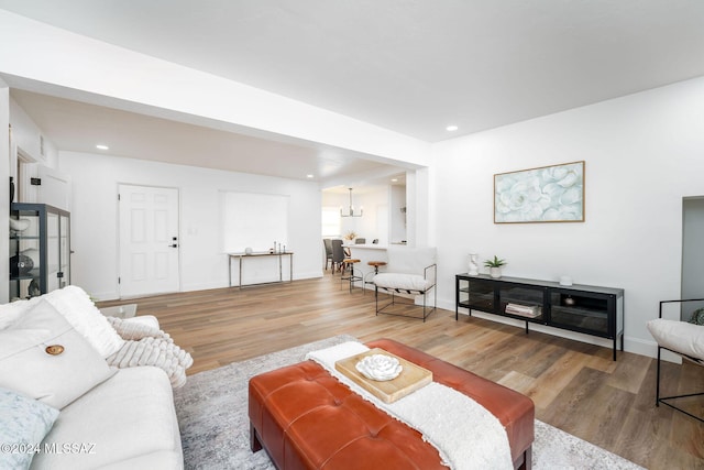 living area featuring baseboards, wood finished floors, and recessed lighting