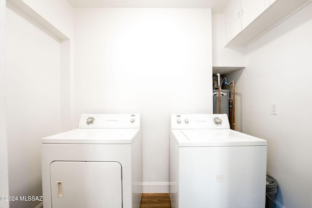 washroom with laundry area, water heater, and washing machine and clothes dryer