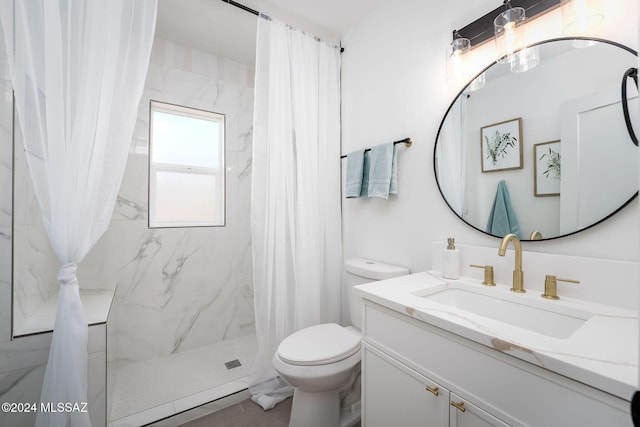 full bath with a stall shower, vanity, and toilet