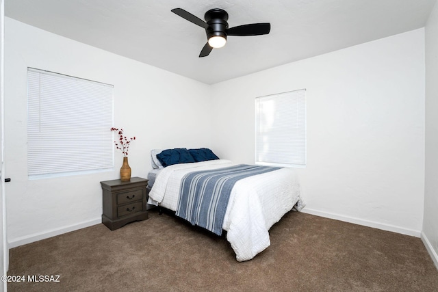 bedroom with a ceiling fan, dark colored carpet, and baseboards