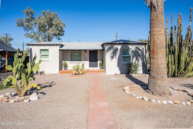 view of front of home featuring a shingled roof and stucco siding