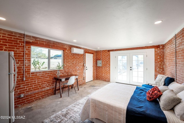 bedroom featuring a wall unit AC, brick wall, access to outside, french doors, and freestanding refrigerator