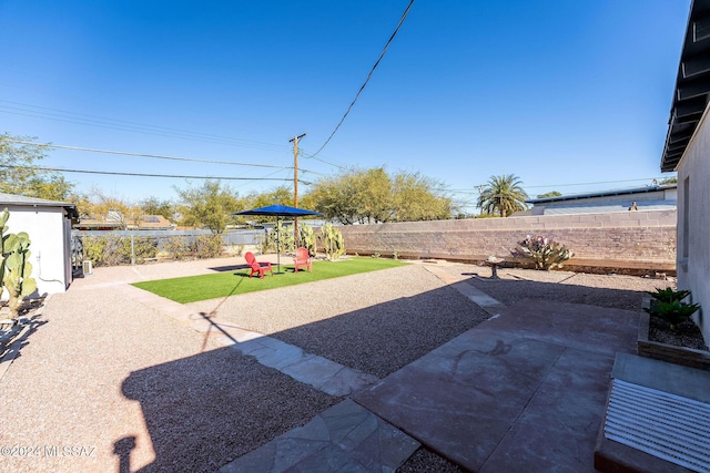 view of yard featuring a patio area, a fenced backyard, and a playground