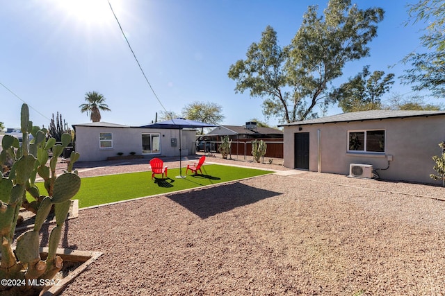 back of house with a yard, fence, and stucco siding