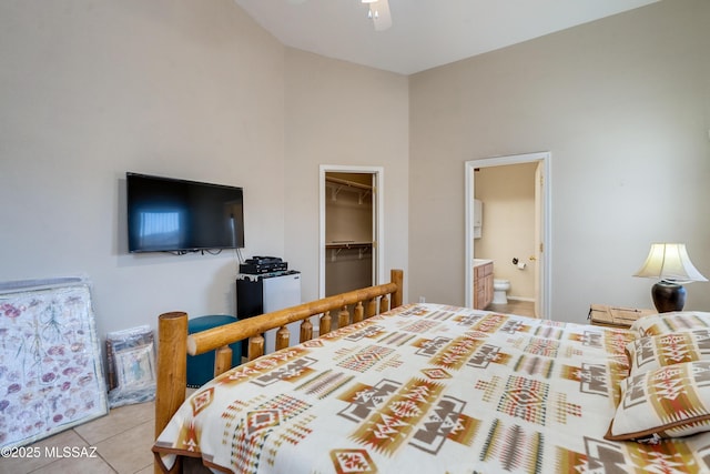 bedroom with a spacious closet, light tile patterned floors, ensuite bath, and a closet