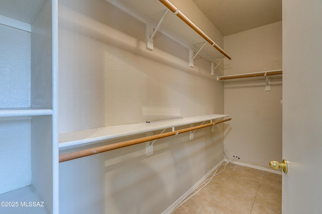 spacious closet with light tile patterned floors