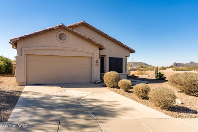 view of front of property with a mountain view and a garage